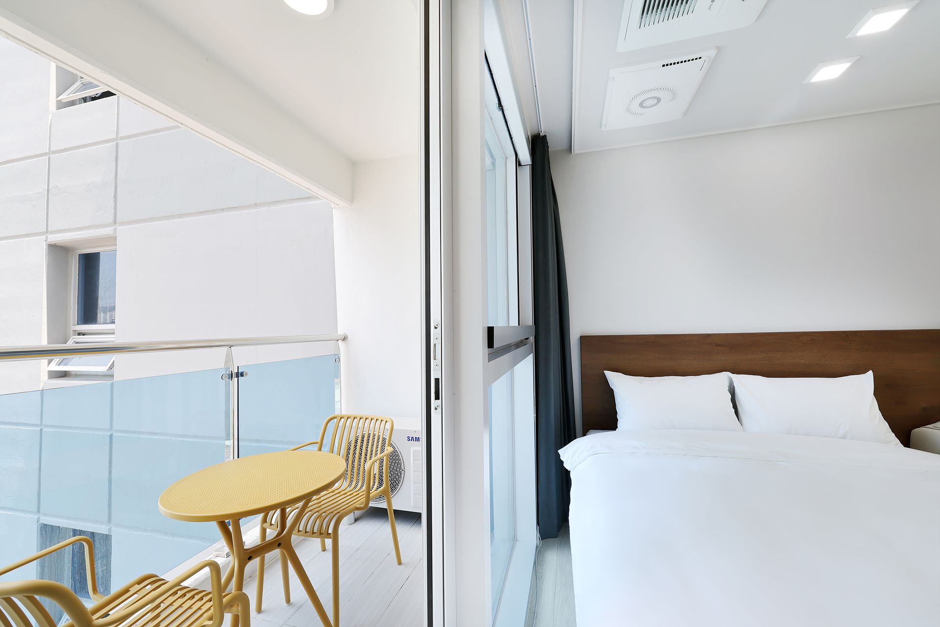 Una habitación de hotel con cama, una mesita, dos sillas y una ventana.