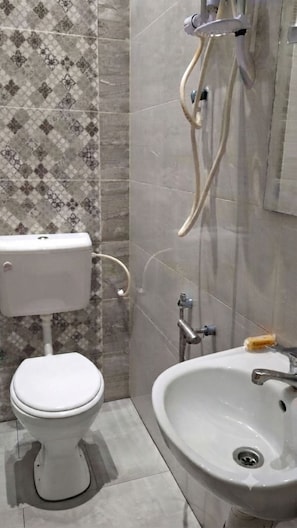 Un baño con inodoro, lavabo y ducha.