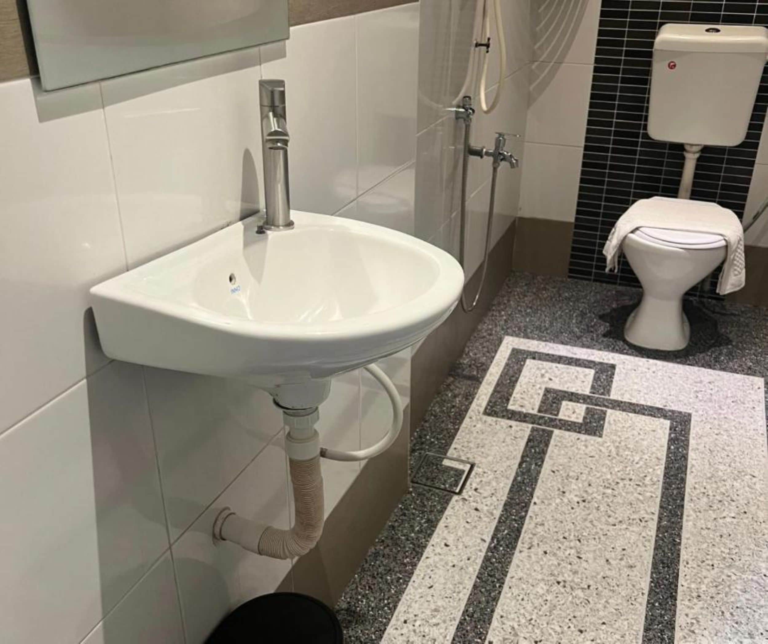 Un bagno con lavandino bianco, un water e una doccia.