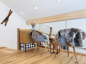 A modern interior with wooden flooring, two chairs with fur throws, and a wooden partition. - Apartment Inari by Interhome (Gortipohl)