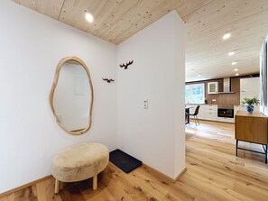 A modern interior with a wooden floor, a round stool, a mirror, and a small rug. - Apartment Laika by Interhome (Gortipohl)