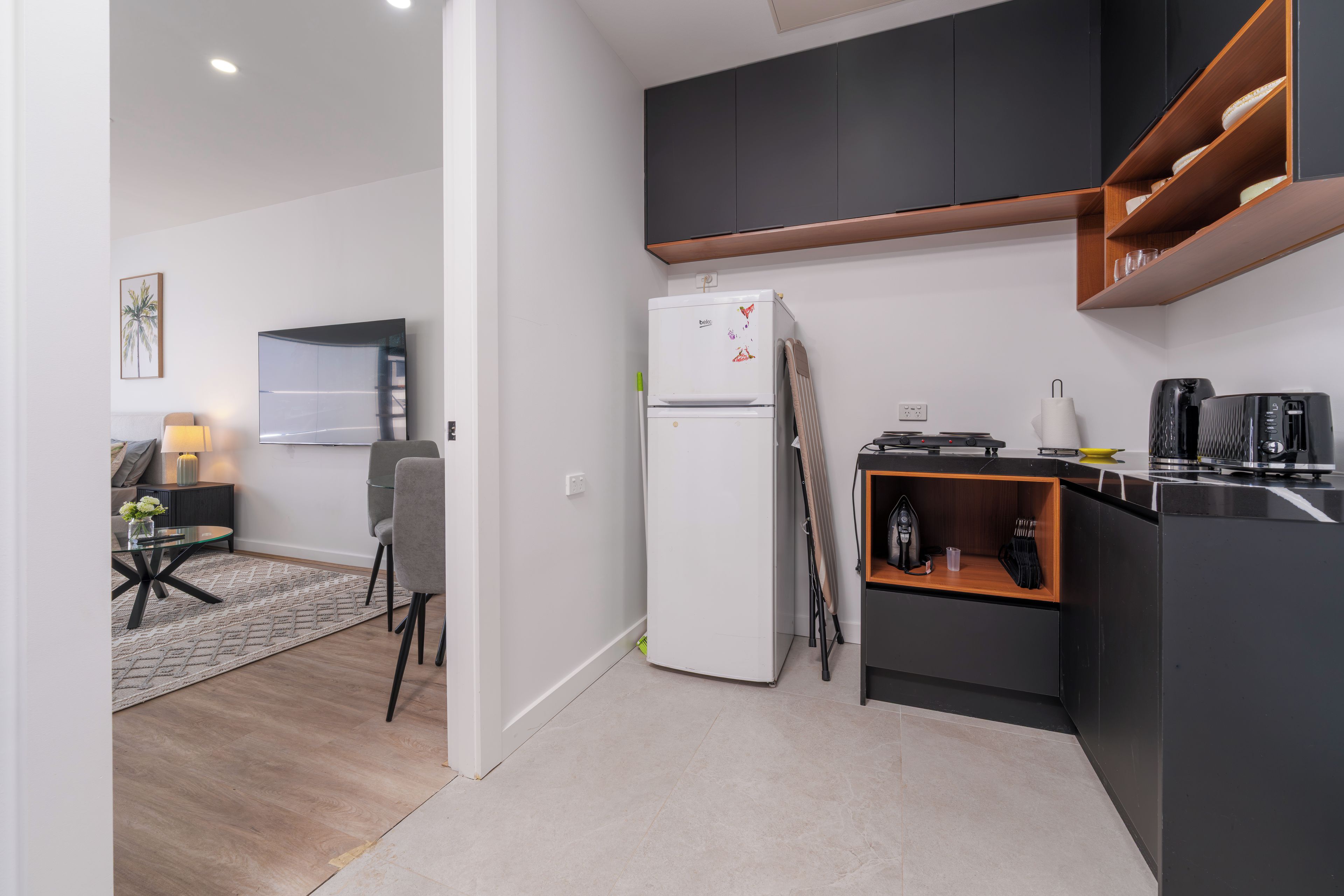 A compact kitchen with a refrigerator, a coffee machine, and a microwave.
