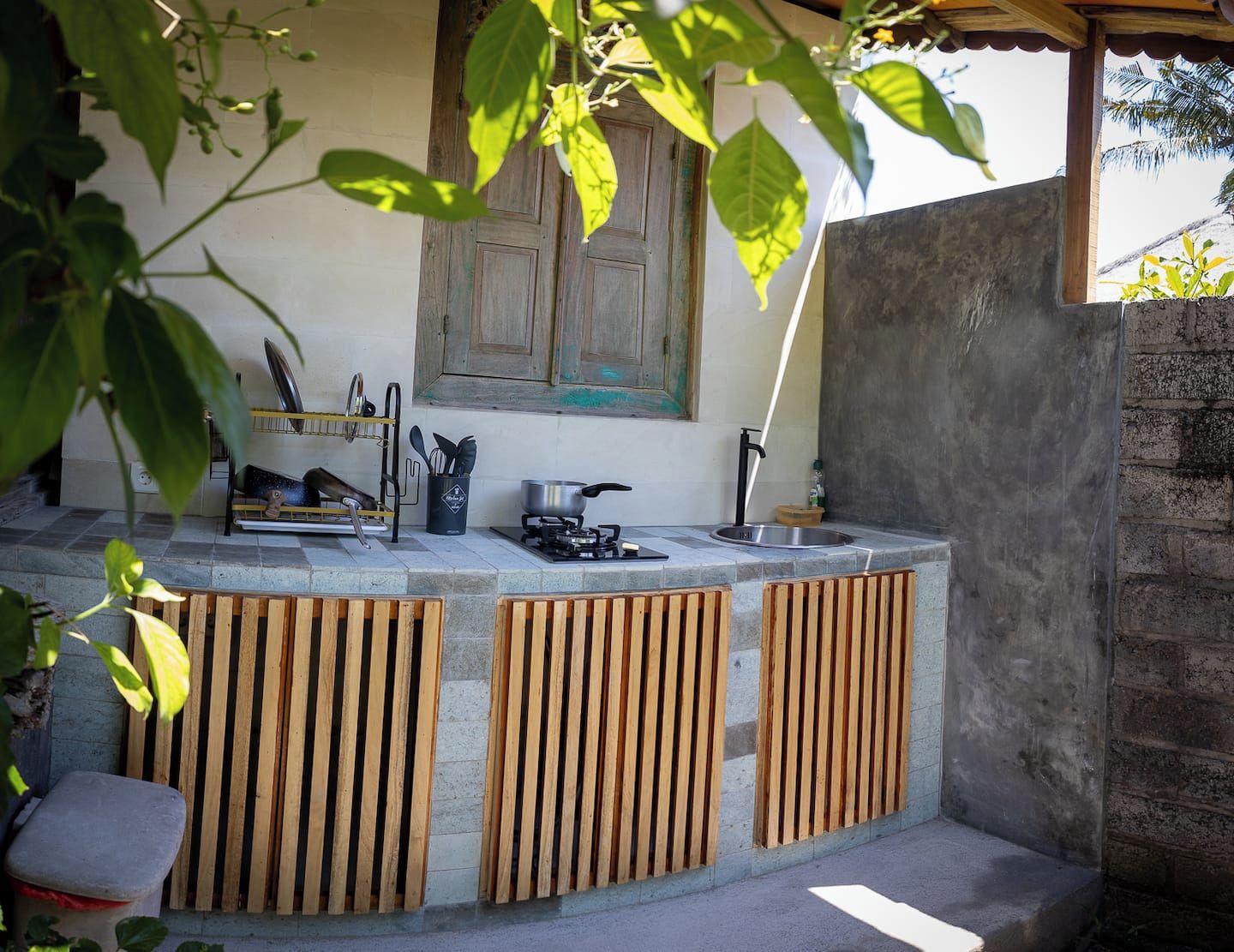 A kitchen area with a wooden counter, a stove, and a window above the sink.