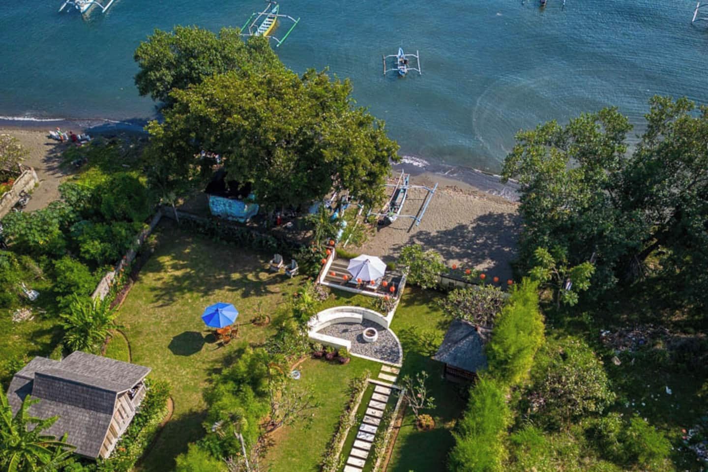 Vista aerea di una struttura con area piscina, un piccolo giardino e un gazebo.