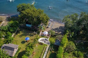 Vista aerea di una struttura con area piscina, un piccolo giardino e un gazebo.