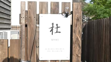 A wooden gate with a sign that reads 'MORI' and some Japanese text.