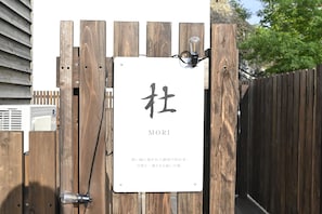 A wooden gate with a sign that reads 'MORI' and some Japanese text.