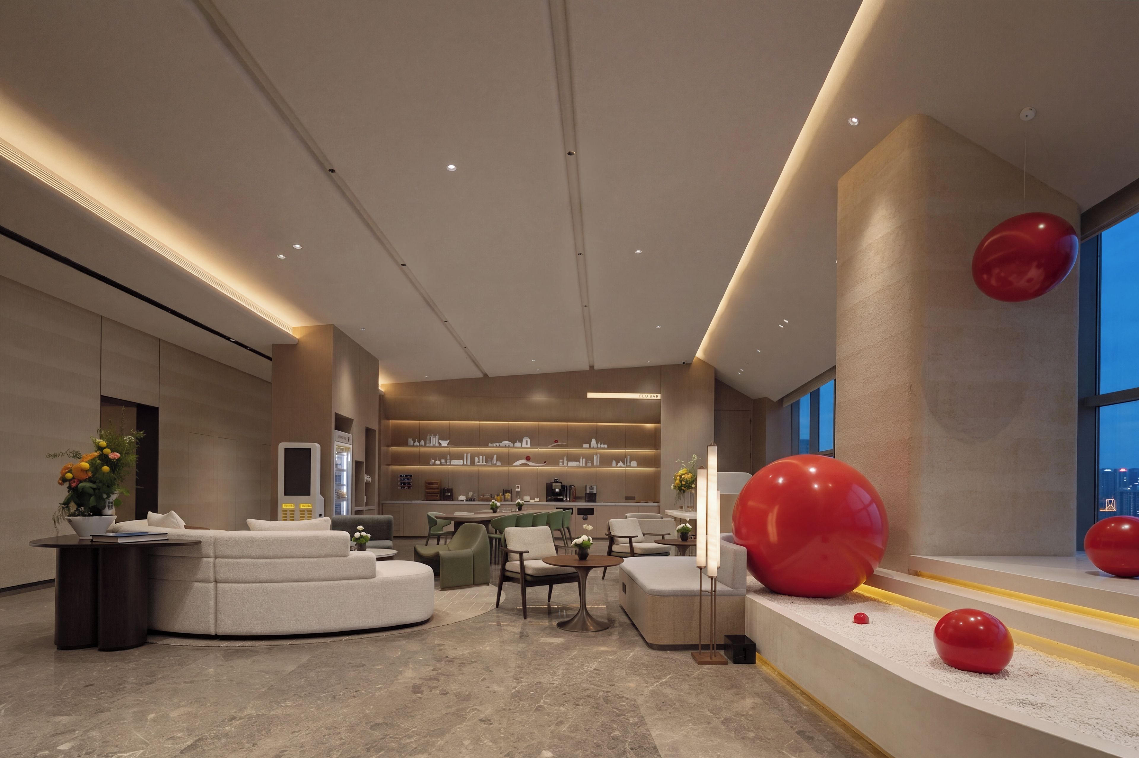 A modern interior with a curved seating area, a bar, and a view of the city.