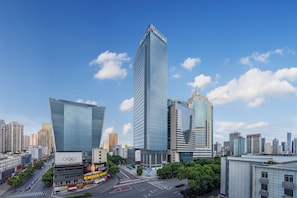 A modern high-rise building with a prominent vertical design, surrounded by other contemporary structures in an urban setting. - YING'nFlO BY LANGHAM CHANGSHA (Changsha)