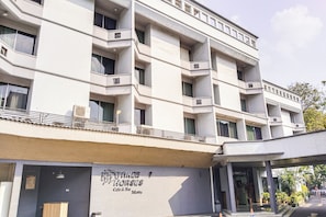 Un edificio de varios pisos con un café y bar llamado 'THREE HORSES' en la planta baja.
