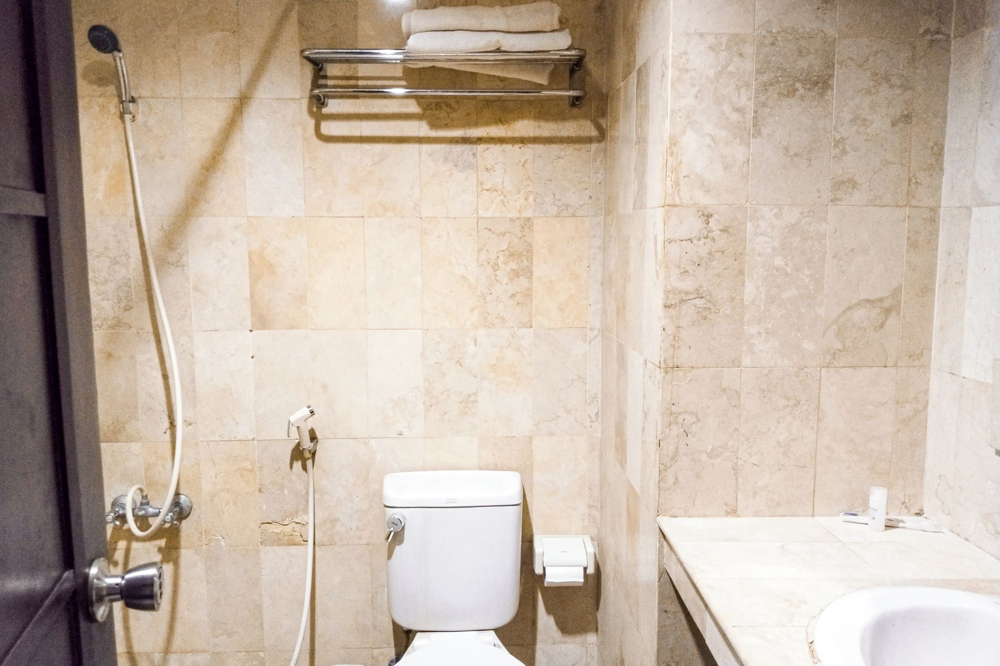 A bathroom with a toilet, a shower, and a sink.