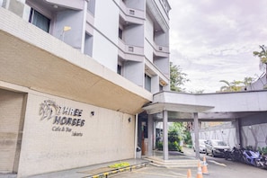 Un edificio con un letrero que dice 'THREE HORSES Cafe & Bar' en Yakarta.