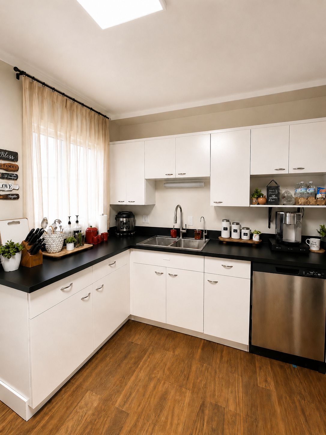 A modern kitchen with white cabinets, a black countertop, and stainless steel appliances.
