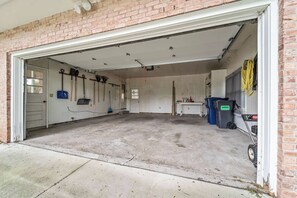 Eine Garage mit Betonboden, Ziegelwand und weißer Tür.