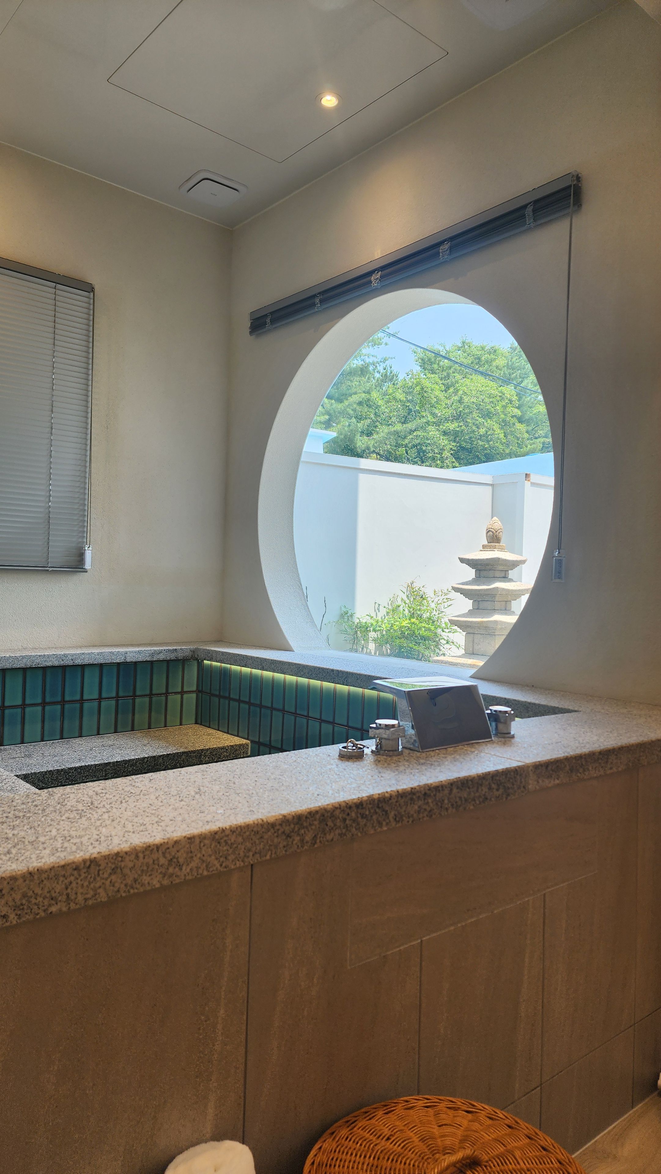 A bathroom with a round window, a sink, and a toilet.