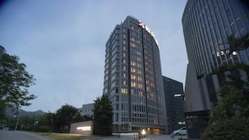 A modern high-rise building with a prominent sign at the top.
