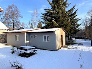 A single-story building with a small porch and a bench.