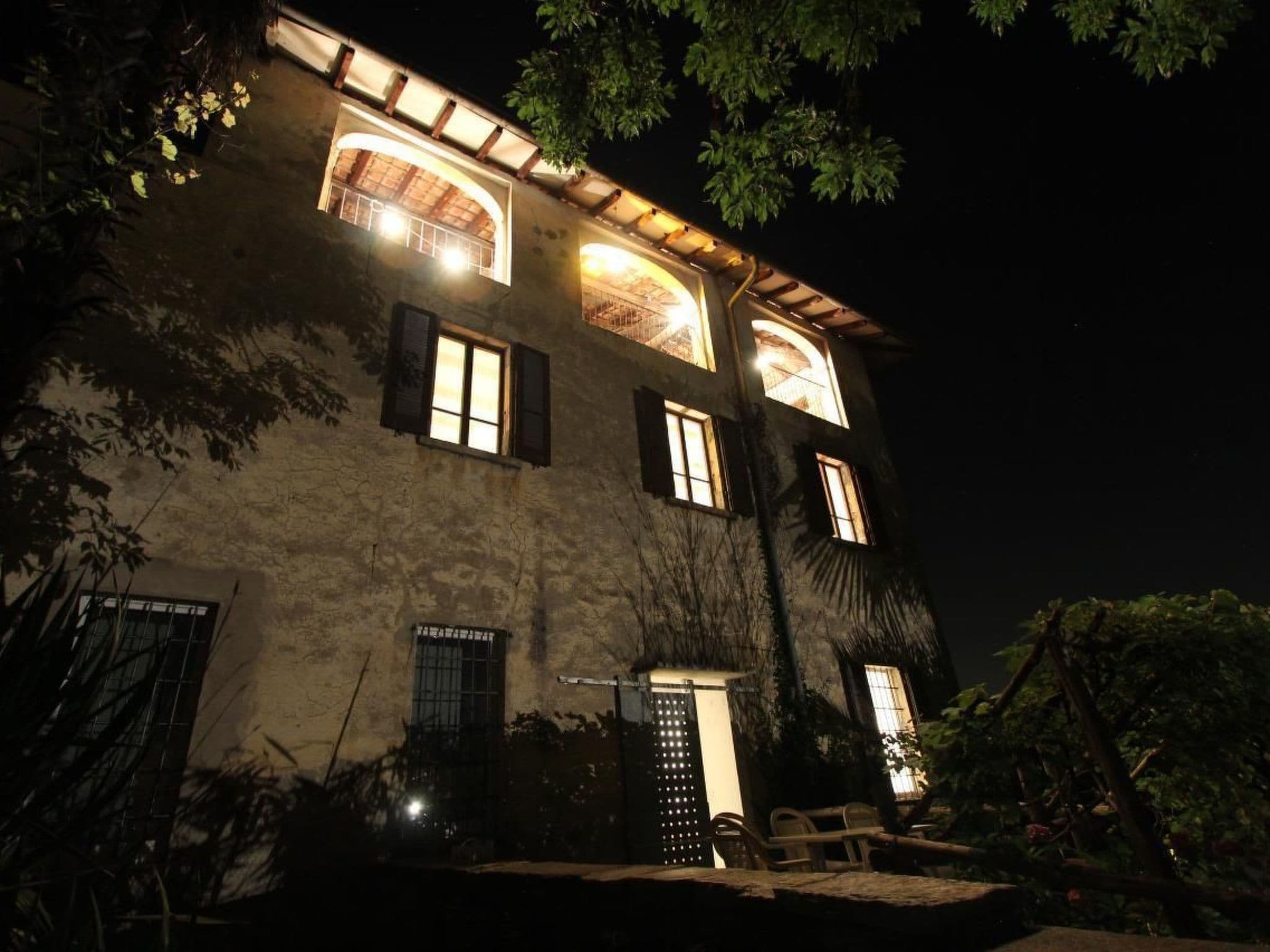 A two-story building with multiple windows, a visible entrance, and a staircase leading to the upper level.