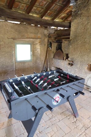 A foosball table in a rustic room with a brick wall and a wooden ceiling. - Casa al Portico by Interhome (Novaggio)