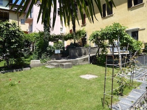 A well-maintained garden with a grassy lawn, stone steps, and a variety of plants. - Casa al Portico by Interhome (Novaggio)