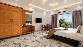 A bedroom with a large wardrobe, a bed, a television, and a view of the outdoors.