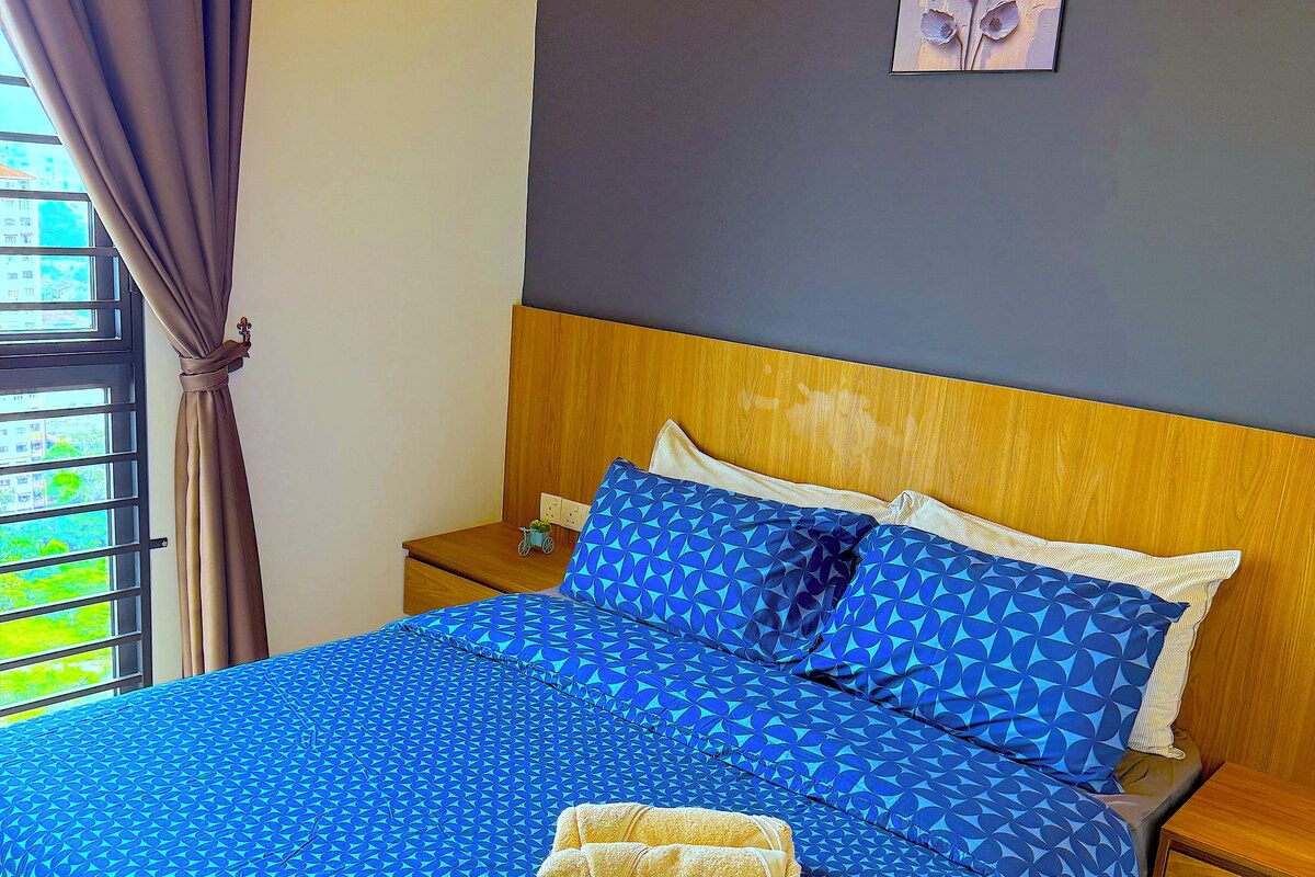Ein Hotelzimmer mit einem Bett, einem Nachttisch, einem Holz-Kopfschild, einem Bild an der Wand und einem Fenster mit Vorhängen.