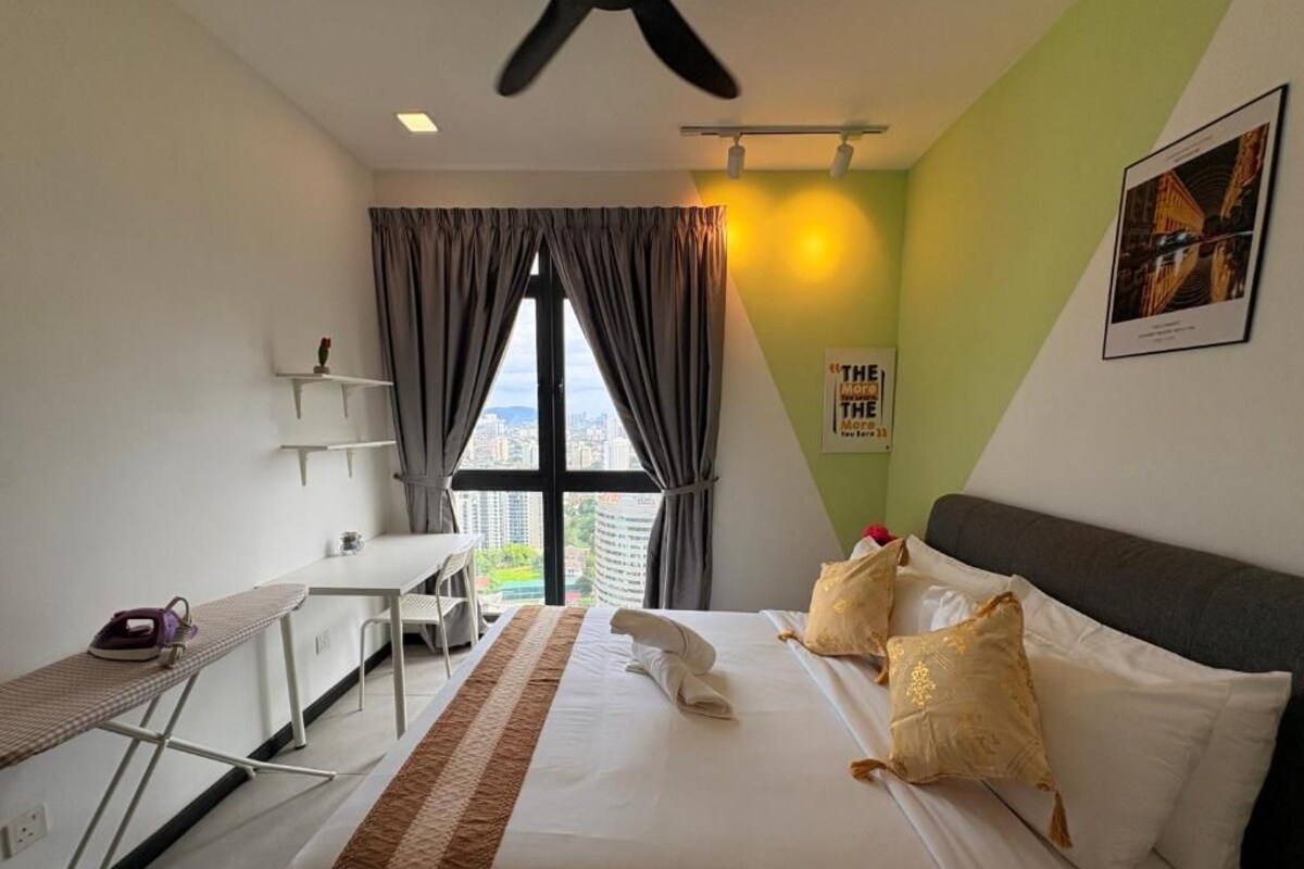 Ein Hotelzimmer mit Bett, Schreibtisch und Blick auf die Stadt.