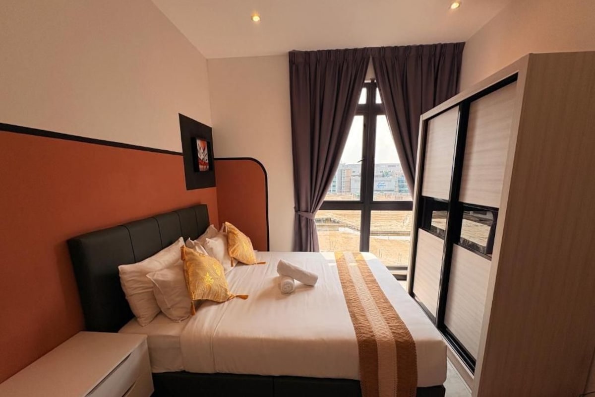Ein Hotelzimmer mit Bett, Nachttisch, einem Fenster mit Vorhängen und Blick auf die Stadt.
