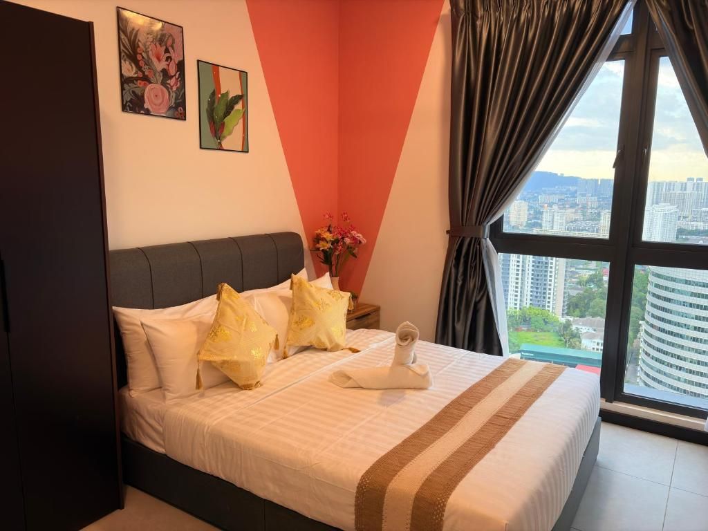 A hotel room with a bed, a nightstand, a vase with flowers, and a city view through the window.