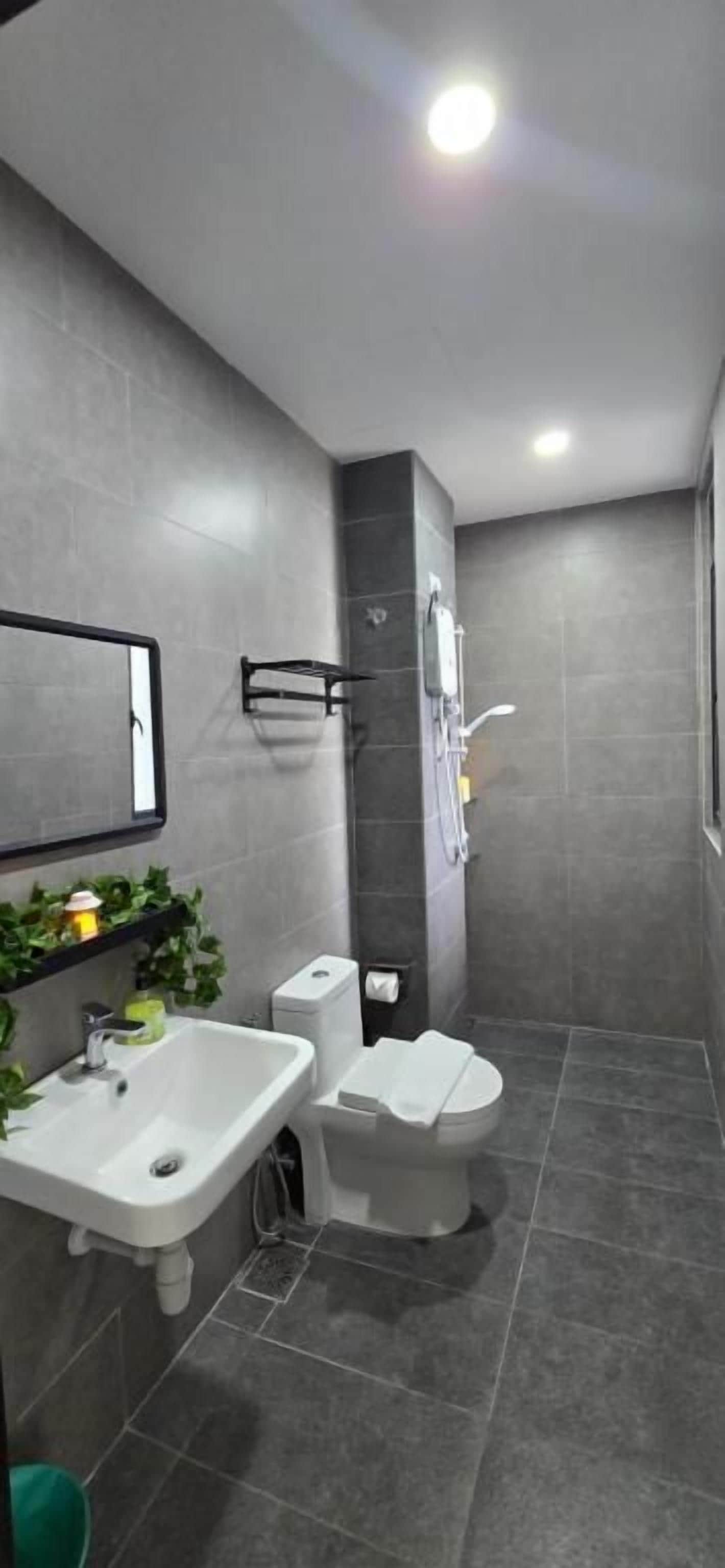 A modern bathroom with a sink, toilet, and shower area.