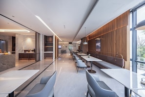 A modern restaurant with marble flooring, wooden accents, and a long counter. - Atour Hotel  Shenbei Wanda Plaza (Shenyang)