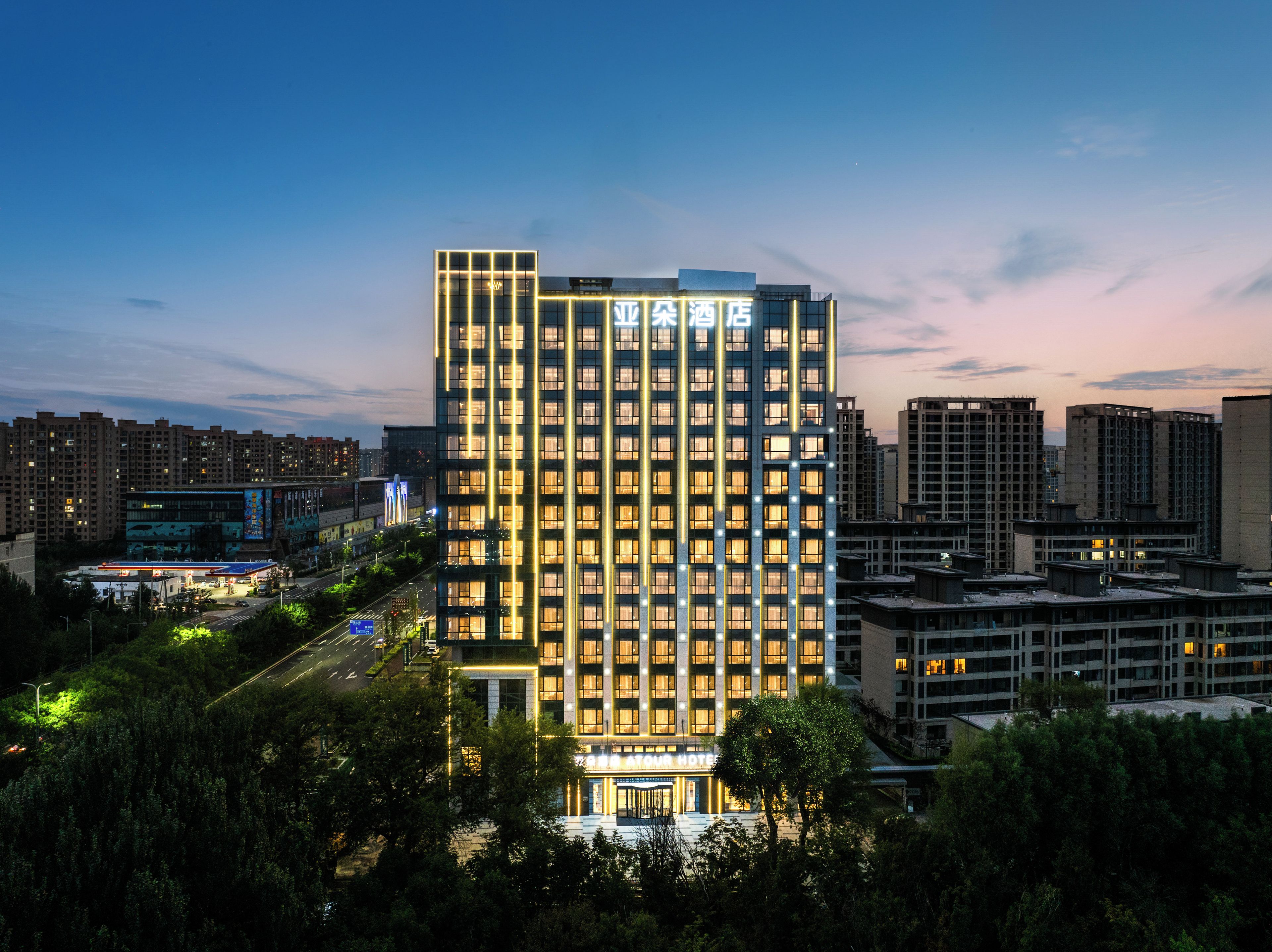 Un hotel moderno de gran altura, con varios pisos, una entrada destacada y una fachada bien iluminada.