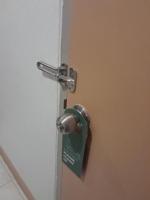 A door with a silver handle and a green sign that reads 'PLEASE CLEAN UP.' - JB House Patong (Patong)