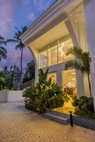 A modern house with a curved facade, large windows, and a well-lit interior.