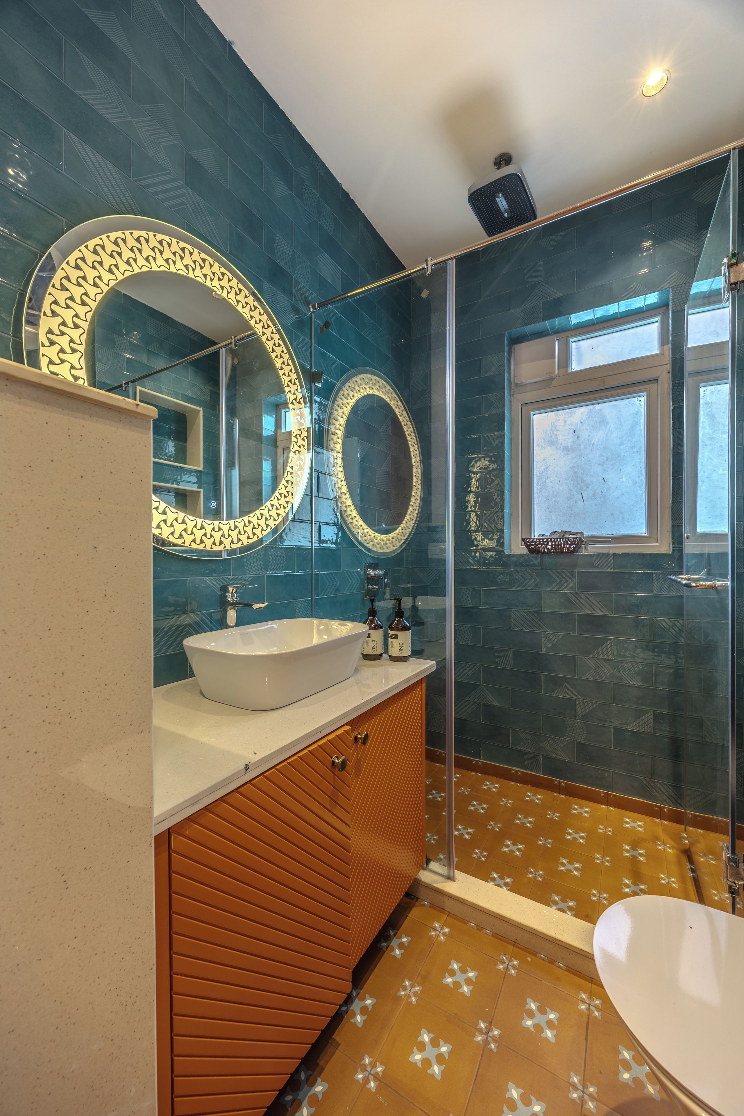 A bathroom with a white sink, two mirrors with decorative frames, a wooden vanity, and a shower area.