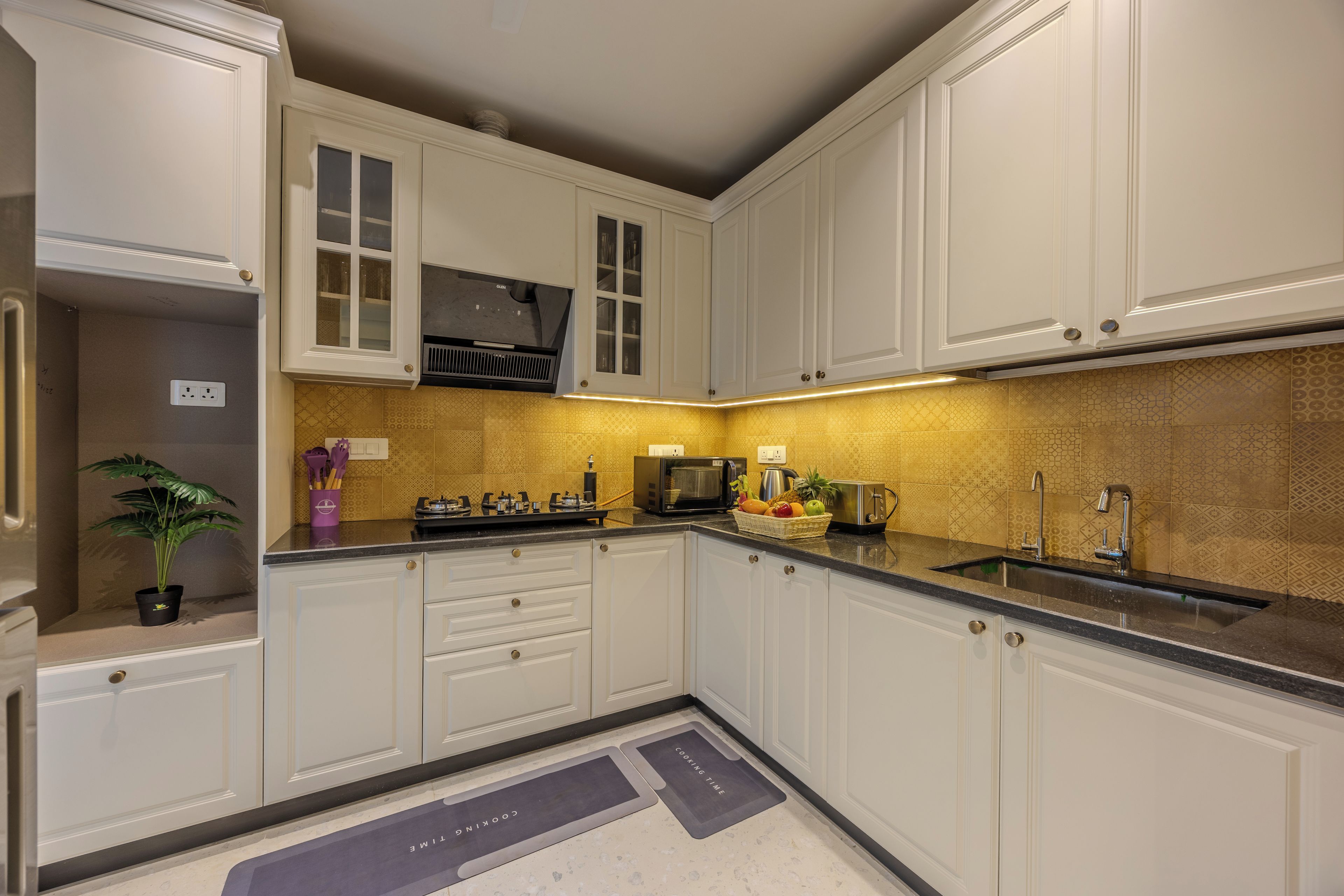 A modern kitchen with white cabinetry, a built-in microwave, and a granite countertop.