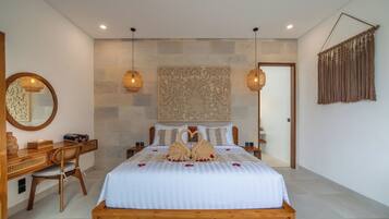 Habitación de hotel con una cama grande, un escritorio de madera, un espejo y un adorno en la pared.