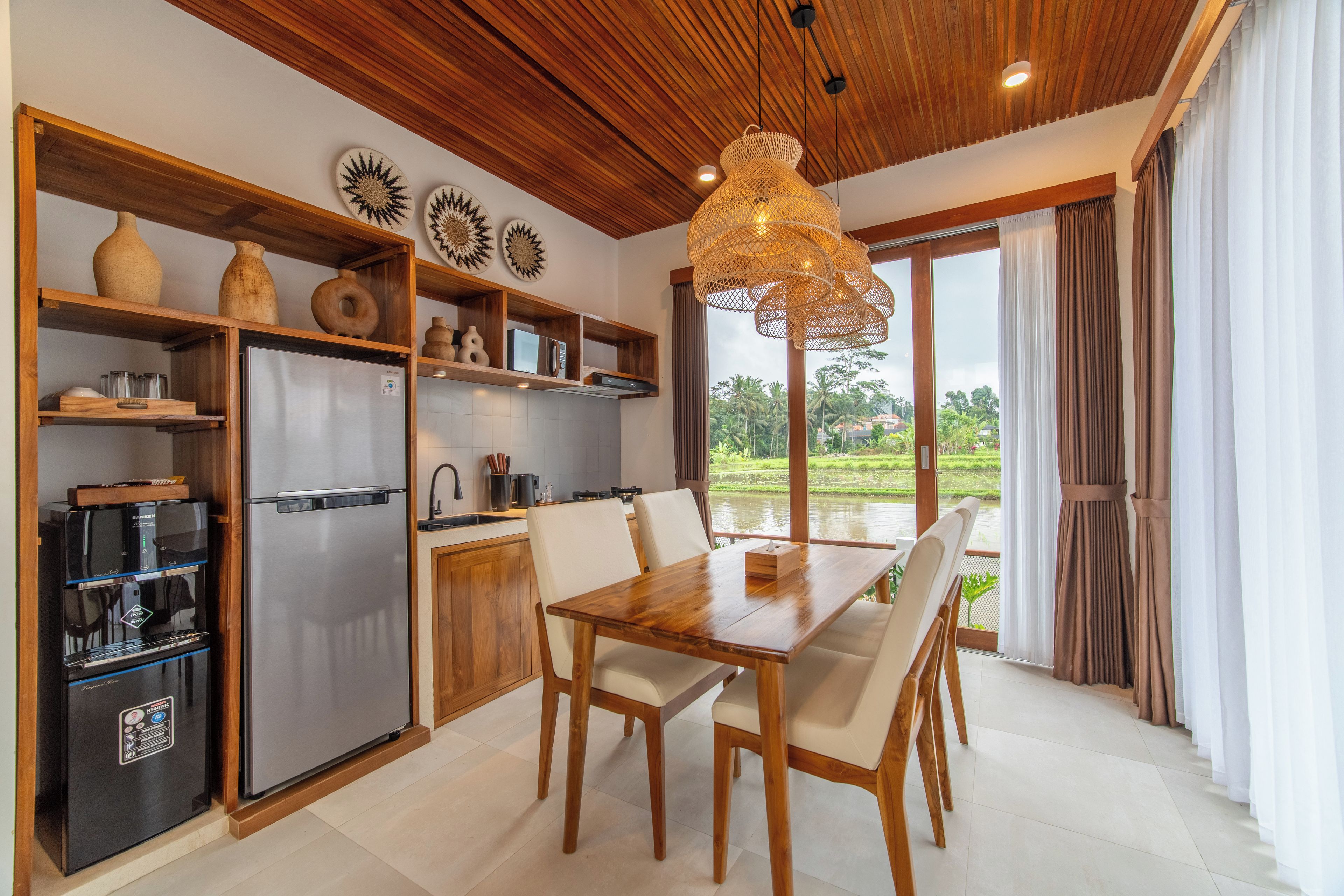 Una cucina moderna con frigorifero integrato, scaffali in legno e zona pranzo con tavolo e sedie.