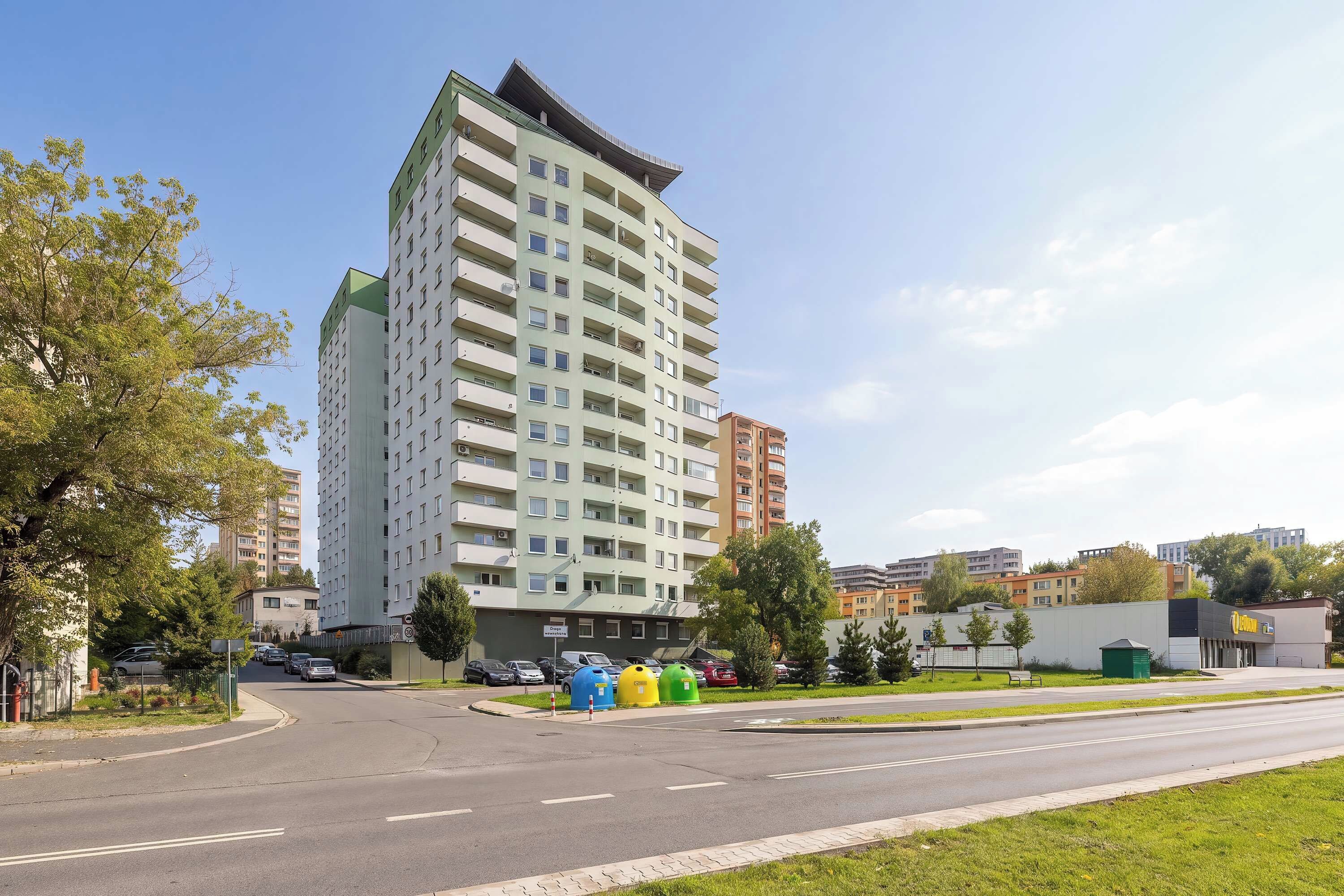 Un immeuble résidentiel à plusieurs étages, doté d’un toit plat et d’une série de balcons.