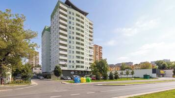 A multi-story residential building with a flat roof and a series of balconies.