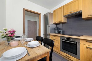 Una cocina moderna con armarios de madera, un refrigerador de acero inoxidable y un horno Bosch.