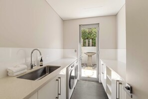A modern kitchen with a sink, faucet, and a bottle of soap. - Bayview on Smith—Poolside Sanctuary & Ocean Vistas (Dunsborough)