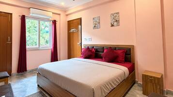 Une chambre à coucher avec un lit, un ventilateur de plafond, une fenêtre avec des rideaux et une porte.