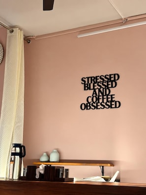 Una pared con una cita motivacional y un estante de madera con varios objetos.
