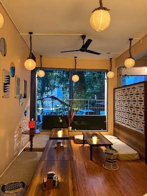 A modern interior with a dining area, wooden furniture, and a ceiling fan. - Stay Berry (Rishikesh)