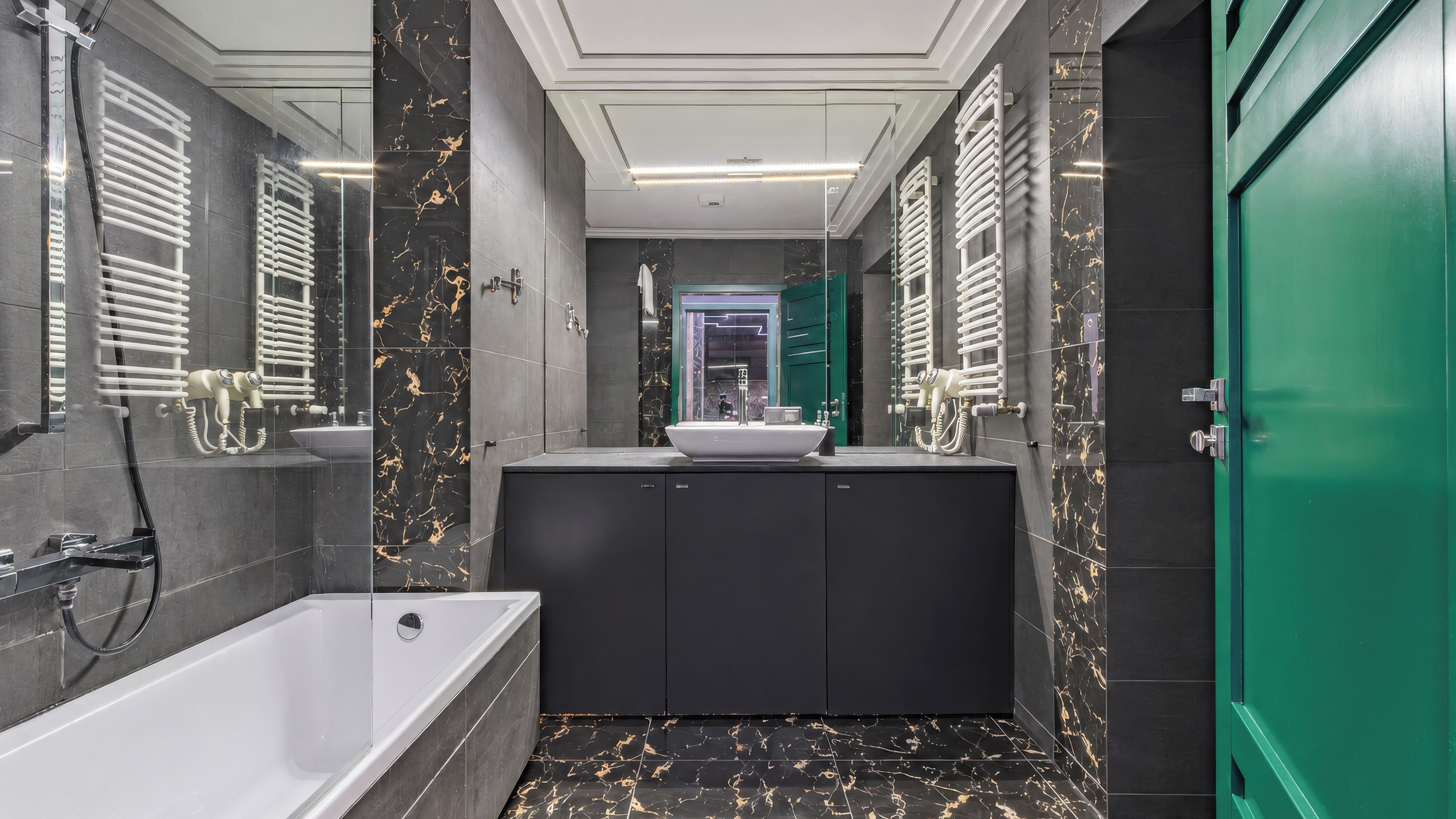 A modern bathroom with a bathtub, a sink, and a green door.