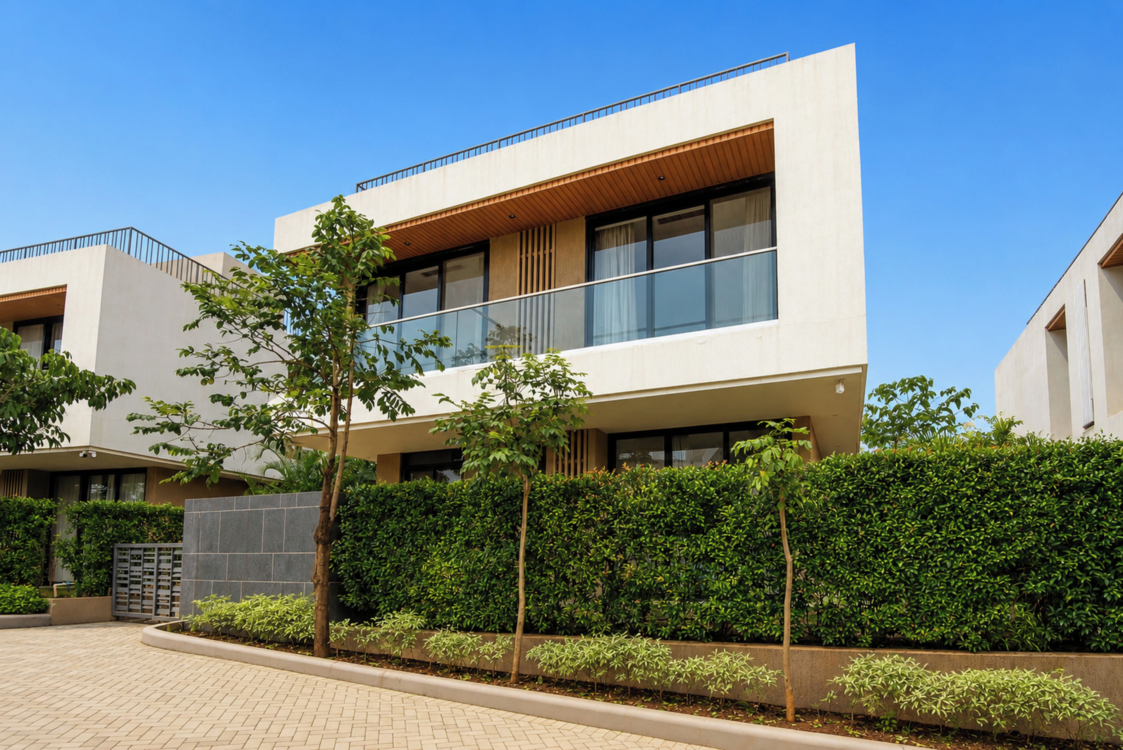 A modern building with a flat roof, large windows, and a balcony.