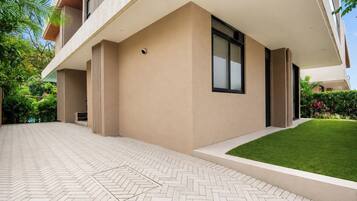 A modern building with a flat roof, large windows, and a paved entrance area.