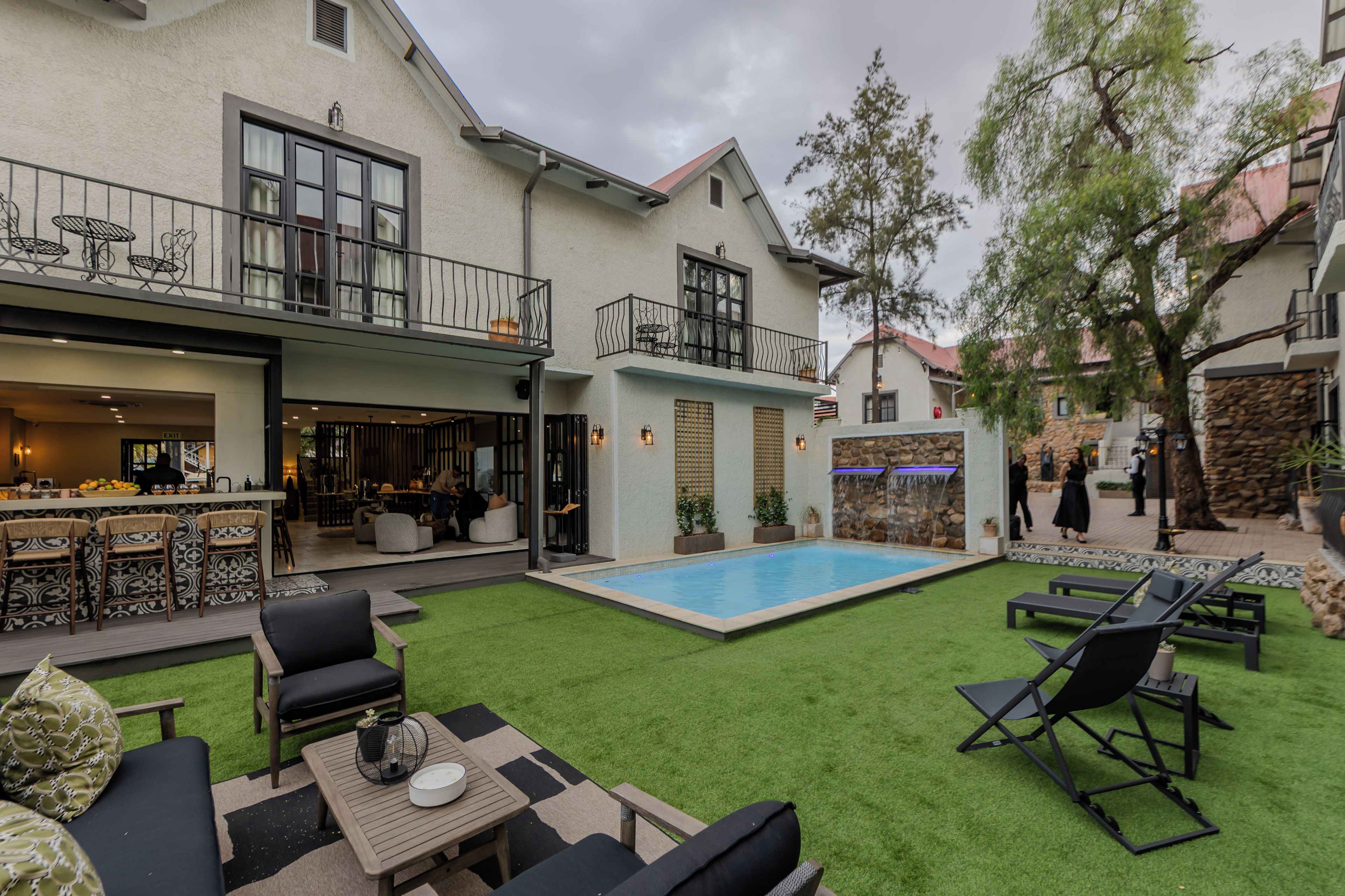Une cour avec une piscine, un espace aménagé pour se détendre en plein air et un coin bar.