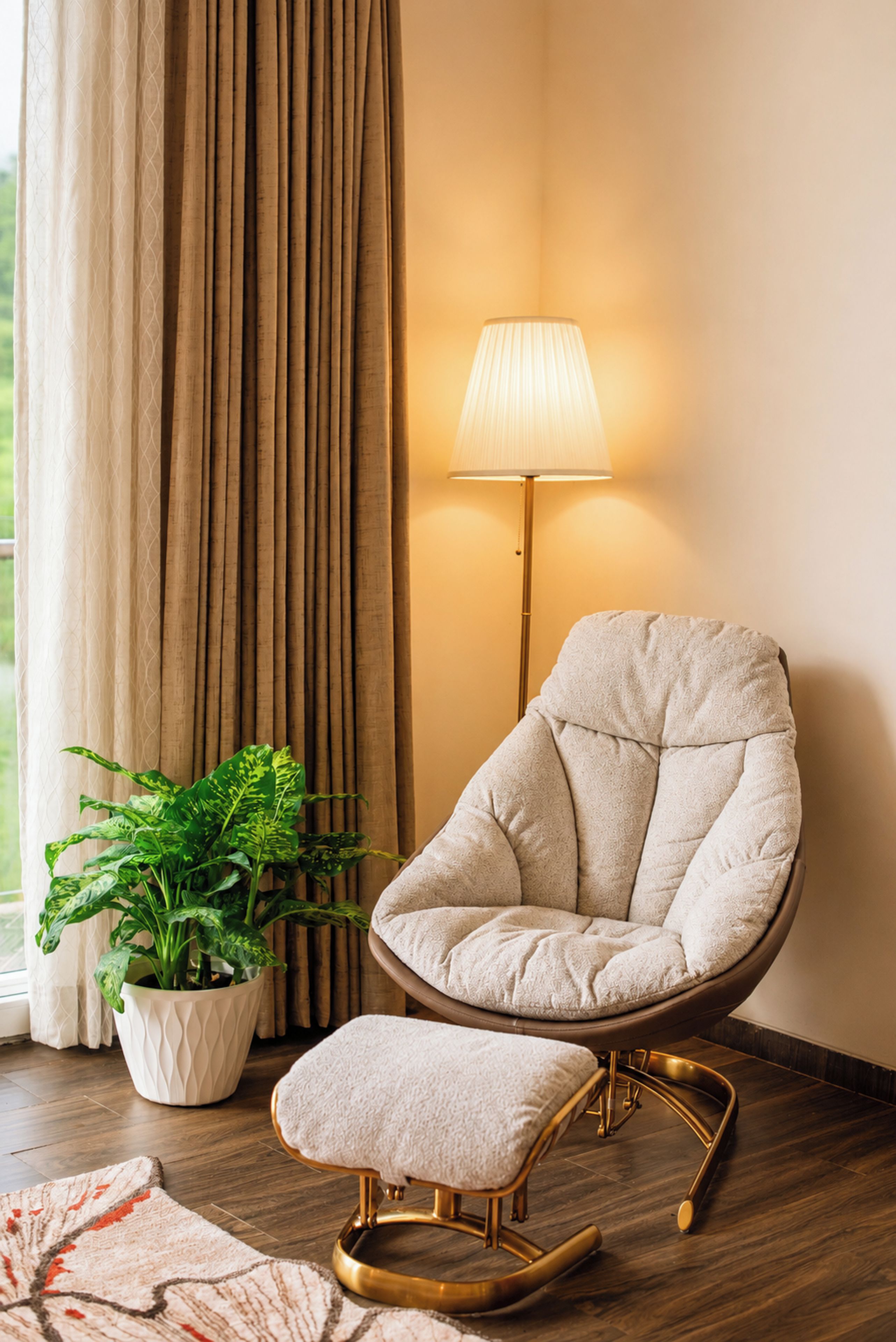 A room with a cushioned chair, a floor lamp, a potted plant, and a patterned rug.